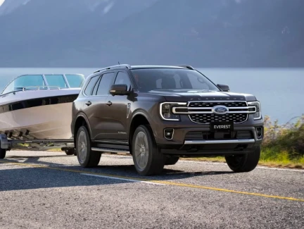 A grey Ford Everest towing a boat on a trailer beside a South Island lake